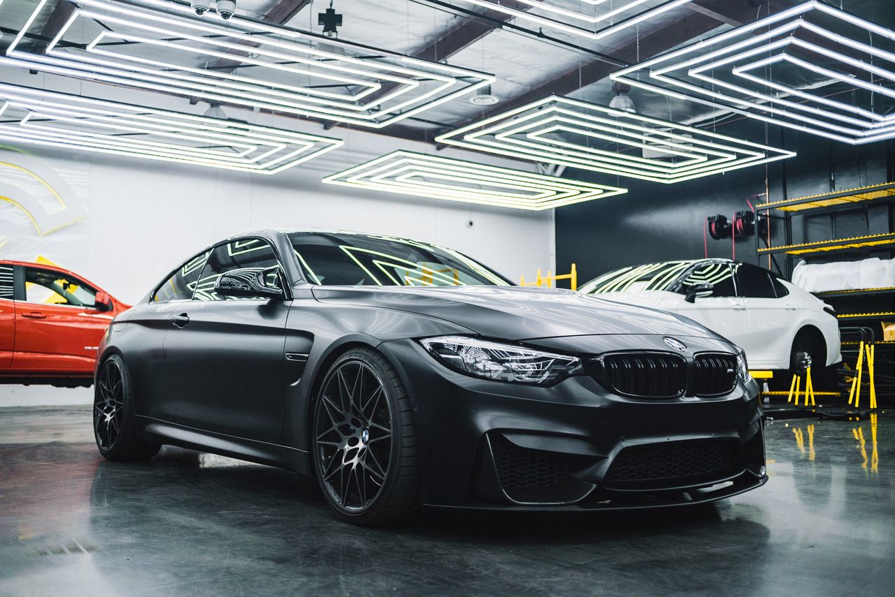 gallery-4 Luxury black car showcased in a modern garage setting, highlighting its sleek design and elegance.
